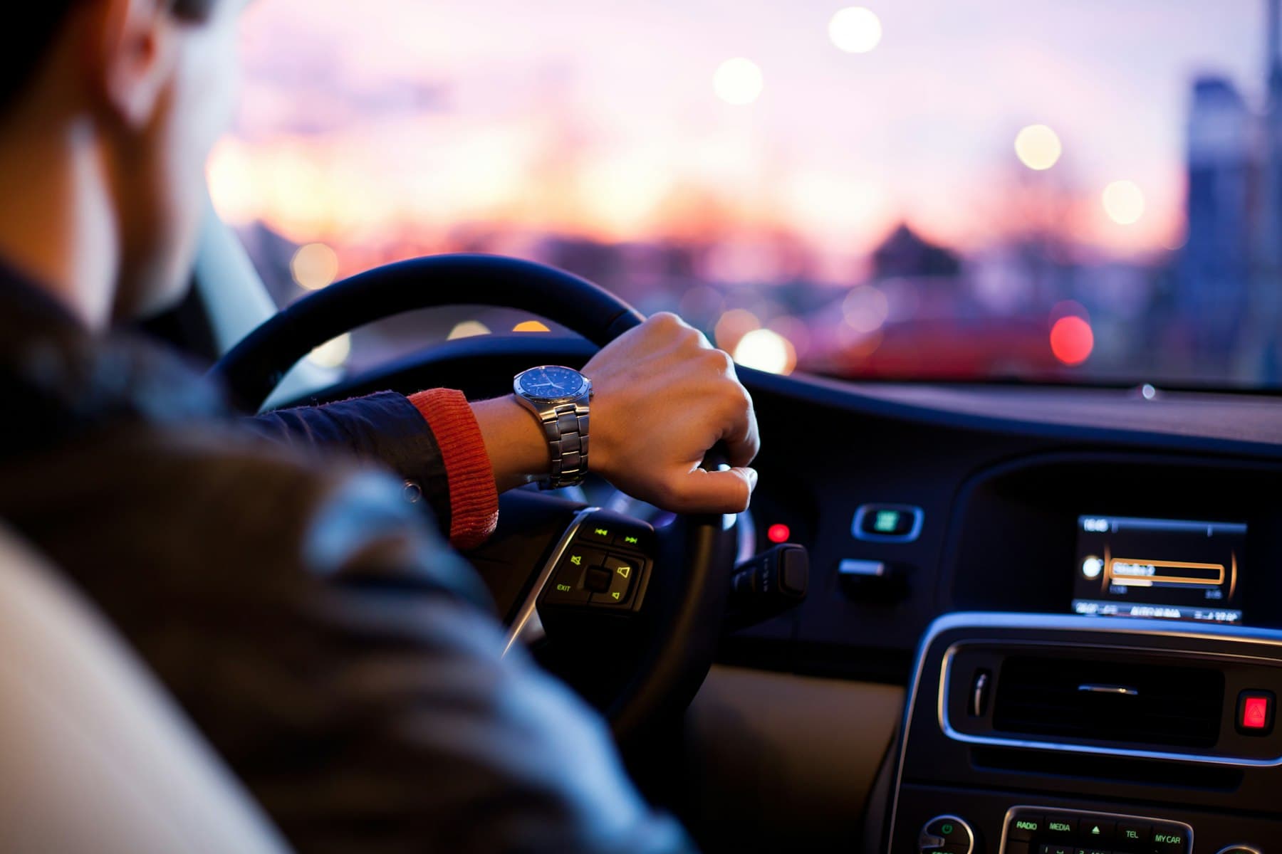 Conduite au crépuscule, mains sur le volant